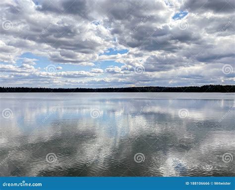 Lake Landscape With Blue Sky And Storm Clouds Reflection In The Water