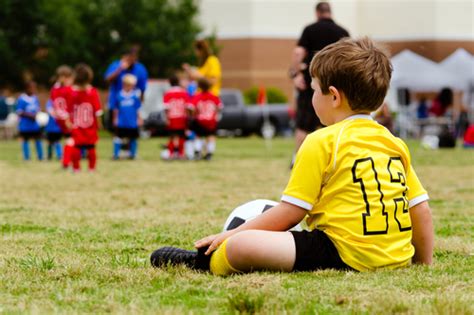 Young Boy Child In Uniform Watching Organized Youth Soccer Or Football