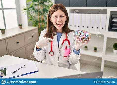 Young Doctor Woman Holding Sweets Candy Pointing Finger To One Self