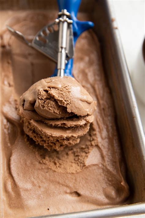 A Scoop Of Chocolate Ice Cream In A Pan With A Blue Spatula On Top