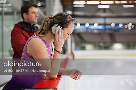 Female Figure Skater With Coach Preparing For Routine In Skating Rink