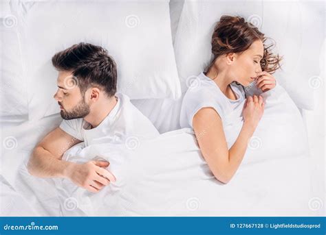 Overhead View Of Young Couple Sleeping Back To Back Stock Photo Image