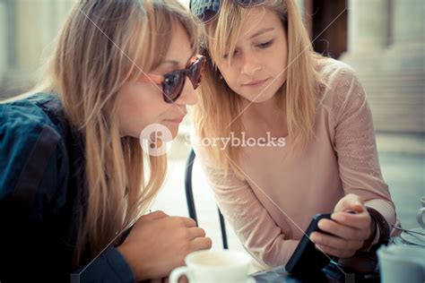 Two Beautiful Blonde Women Talking At The Bar In The City Royalty Free