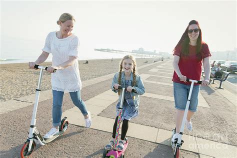 Lesbian Couple And Daughter Riding Push Scooters Photograph By Caia Imagescience Photo Library