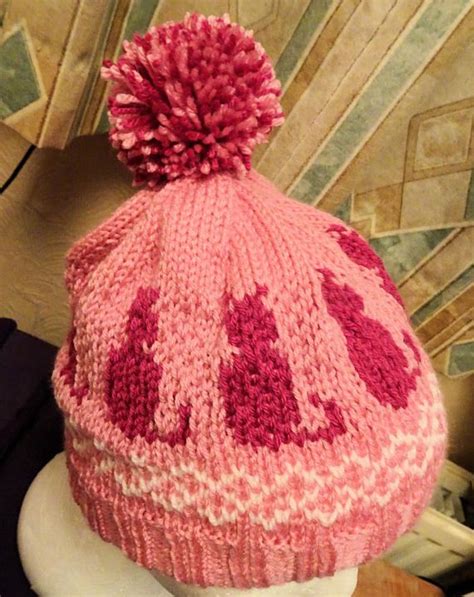 A Pink Knitted Hat With Hearts On It