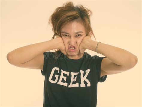 Studio Shot Of Young Asian Woman With Arms Crossed And Messy Hai Stock