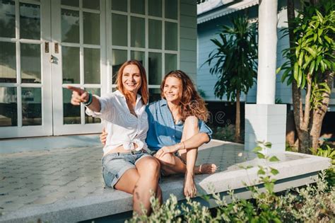 position lesbienne heureuse de couples sur la terrasse leur maison de campagne photo stock