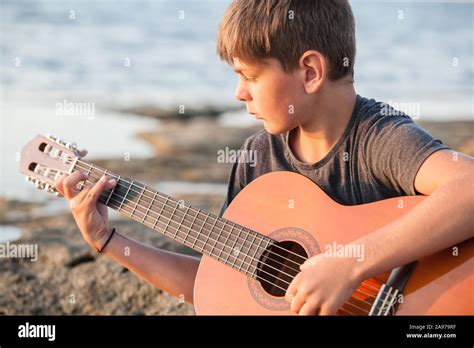 Boy Playing Guitar By The Ocean Stock Photo Alamy