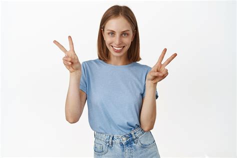 free photo happy modern blond girl showing peace v signs and smiling kawaii express