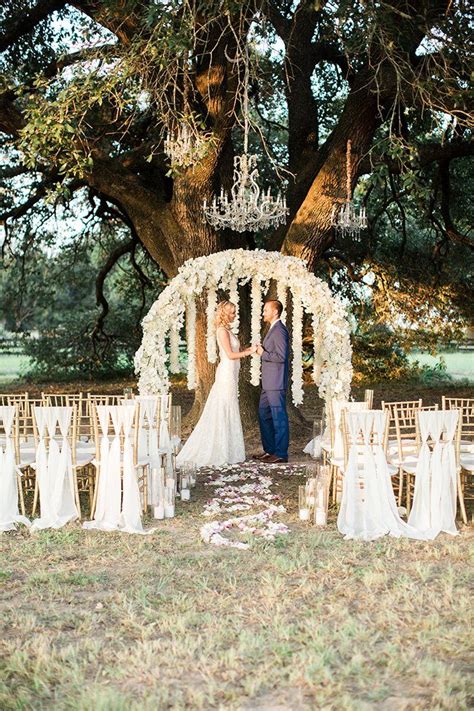 Outdoor Country Wedding Ceremony With Floral Arch And A Chandelier
