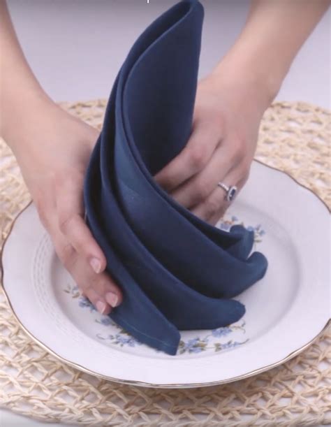 A Woman Is Placing Napkins On Top Of A Plate