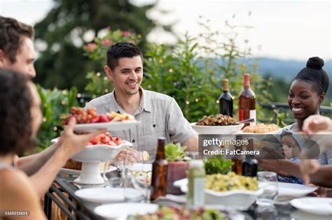 A Group Of Young Adult Friends Dining Al Fresco On A Patio High Res