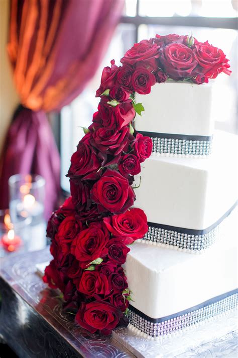 Red Roses Cascading Off Of Cake With Rhinestones Tiered Wedding Cake