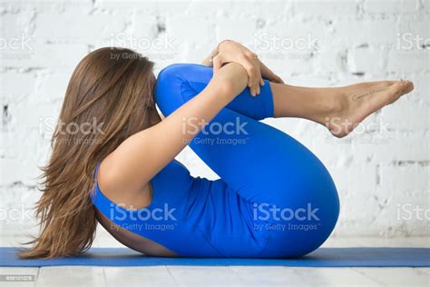 Young Attractive Woman In Knees To Chest Pose White Studio Stock Photo