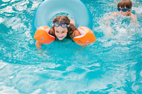 Las Niñas Están Nadando En La Piscina Por Un Día De Verano Imagen De