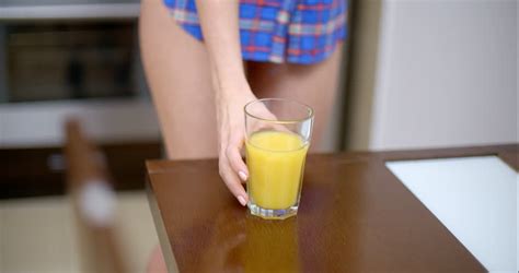 Sexy Bottomless Woman Wearing Blue Violet Shirt Only Drinking Orange Juice While At The Kitchen