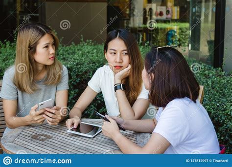 Cheerful Asian Young Women Sitting In Cafe Drinking Coffee With Friends And Talking Together