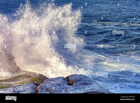 Waves Crashing Against Rocks With Spray Stock Photo Alamy