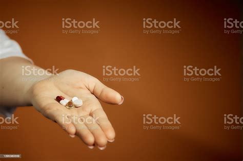 Woman Holding A Pill In Her Hand Treatment Of Colds Stock Photo