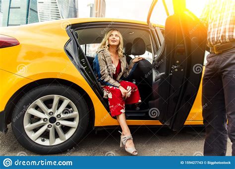 Photo Of Young Blonde In Long Dress Sitting In Back Seat Of Taxi In