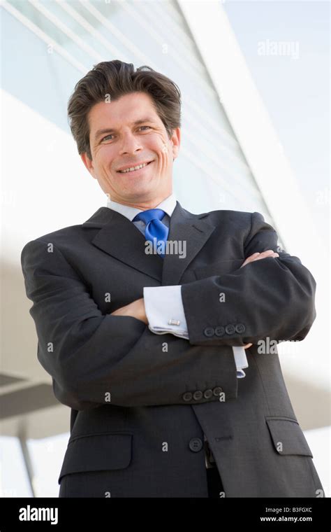 Businessman Standing Outdoors By Building Smiling Stock Photo Alamy