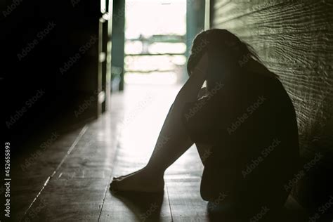 Sad Lonely Little Girl Crying While Sitting On The Floor In Dark Room