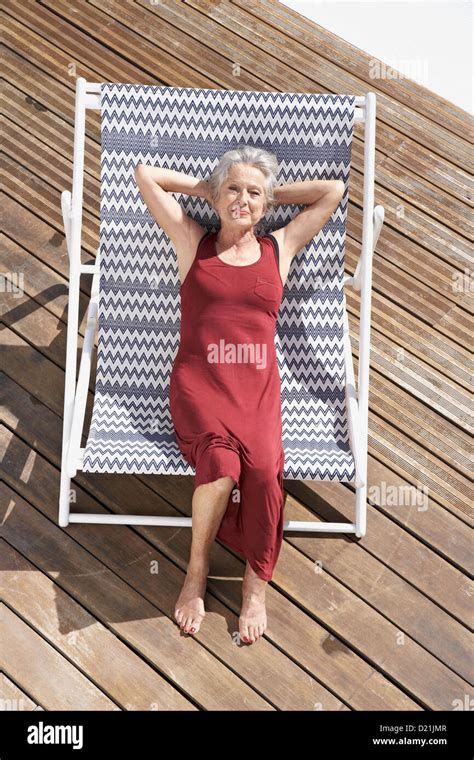 Spain Senior Woman Relaxing On Deck Chair At Beach Stock Photo Alamy