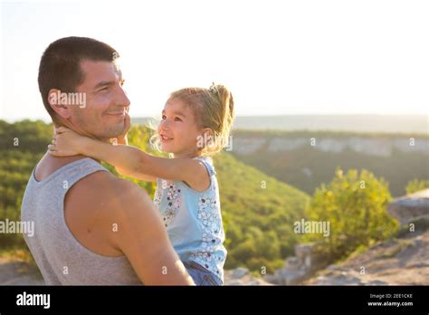 The Father And Daughter Hug Tightly The Girl Holds The Father By The