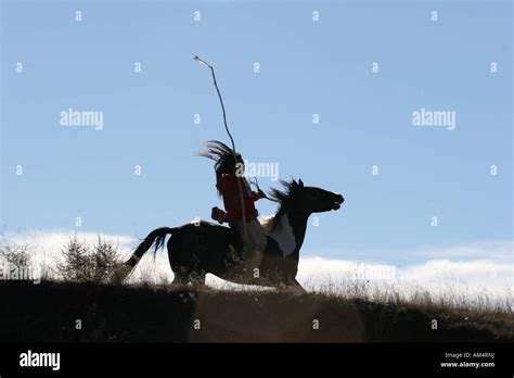 A Native American Indian Man Silhouetted Riding Horseback Looking For