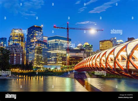 Calgary Downtown At Dusk With Peace Bridge Over Bow River Alberta