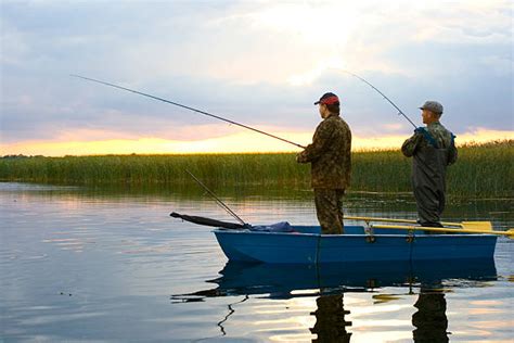 520 A Silhouette Of Two Men Fishing At Sunset Stock Photos Pictures