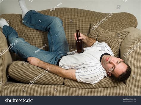 A Drunk Man Is Passed Out On The Couch From Drinking Too Much Beer