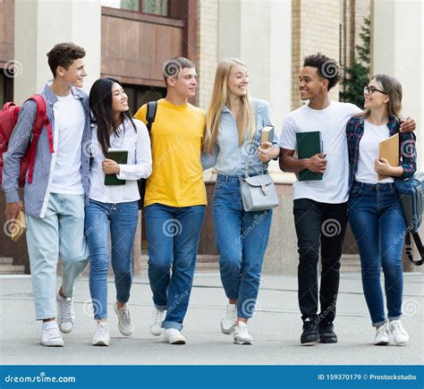 College Students Walking In Campus And Talking Outdoors Stock Image