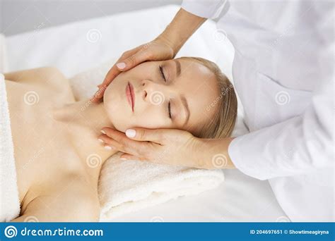 Beautiful Caucasian Woman Enjoying Facial Massage With Closed Eyes In Spa Salon Relaxing