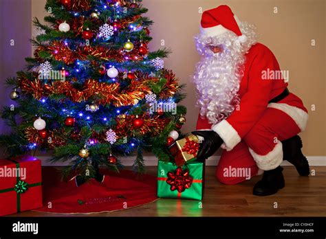 Foto De Santas Claus Entregando Regalos Y Poner Los Regalos Bajo El