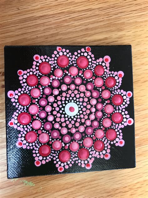 A Black And Pink Painting On A Wooden Surface With Circles In The