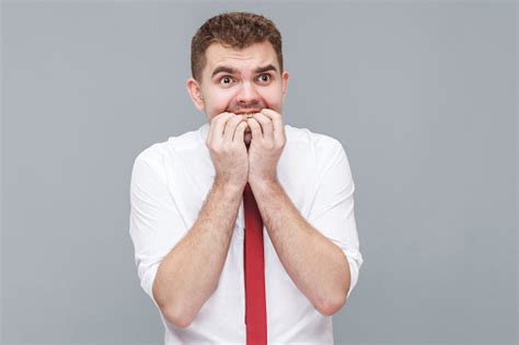 Man Bitting His Nails And Looking With Nervous Worry Face Stock Photo