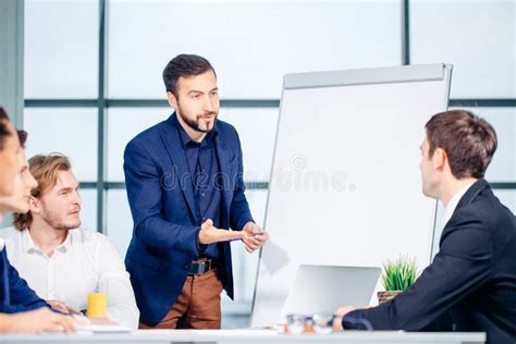 Businessman Presenting To Colleagues At Meeting Stock Photo Image Of