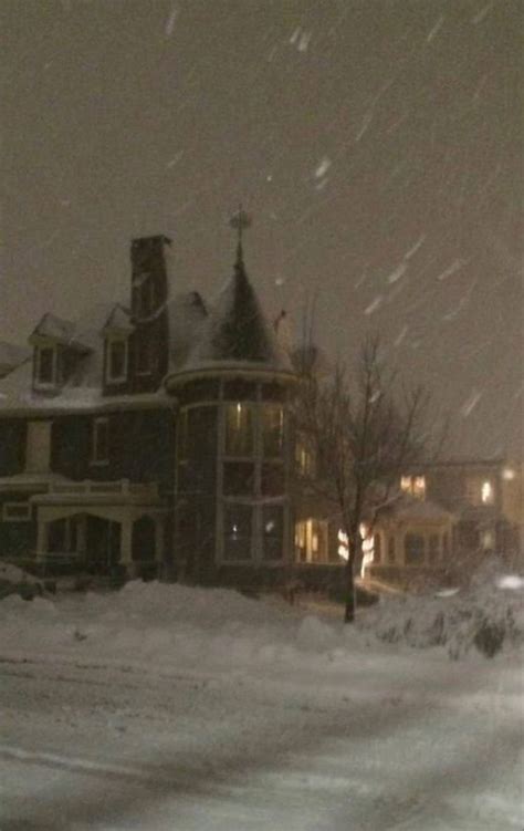 A Snow Covered Street In Front Of A Large House