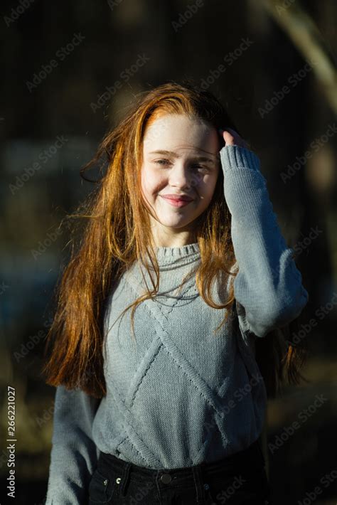 Portrait Of Cute Twelve Year Old Girl With Fiery Red Hair Posing In The