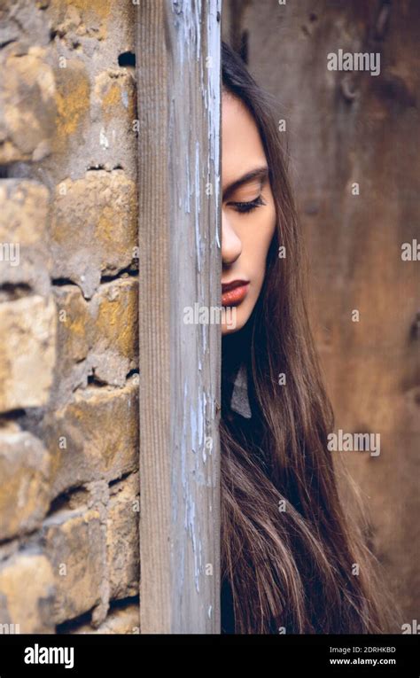 Young Woman Hiding Behind Wall Stock Photo Alamy
