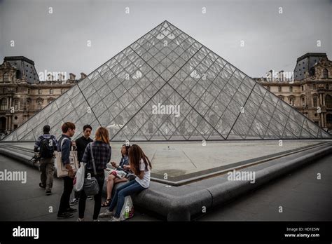 Tourists In The Louvres Central Courtyards With The Louvre Pyramid And