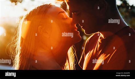 Close Up Photo Of A Caucasian Couple Kissing In The Light Of The Sun Having A Romantic Moment