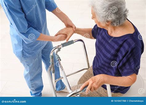 Caretaker Helping Elderly Woman With Walking Frame Stock Photo Image