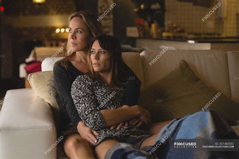 Lesbian Couple Embracing Each Other In Living Room At Home — Indoors