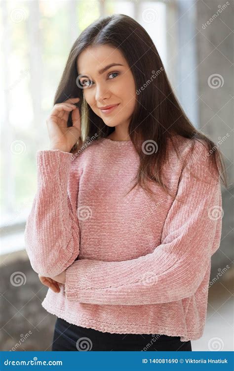 Freestyle Girl In Sweater Standing Indoors Looking Camera Smiling
