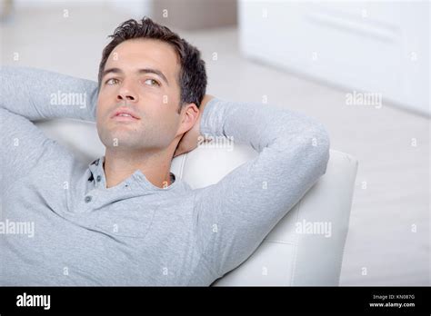 Young Handsome Man Relaxing On Couch Laying And Dreaming Stock Photo