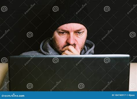 Man Sitting Behind The Computer Monitor Looking At Computer Screen