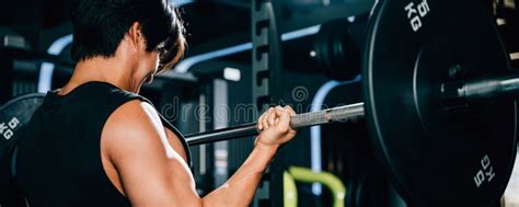A Determined Bodybuilder Lifting Heavy Barbells In The Gym Stock Photo