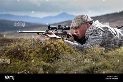 Deer Stalker Aiming Rifle With Telescopic Sight Stock Photo Alamy